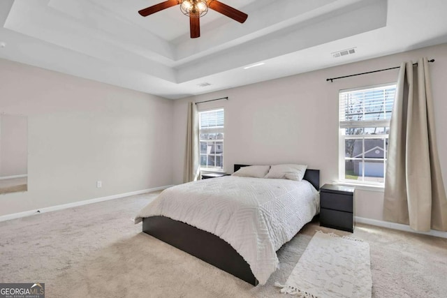 bedroom with visible vents, a raised ceiling, carpet, and baseboards