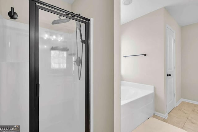 full bathroom featuring tile patterned floors, baseboards, a bath, and a shower stall