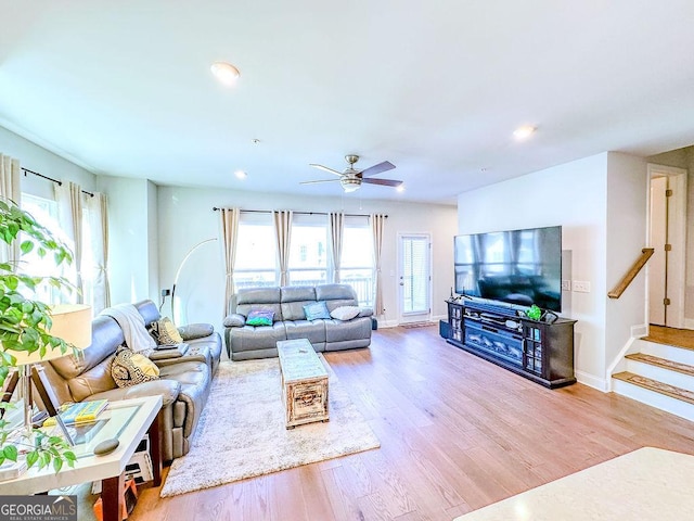 living area featuring baseboards, plenty of natural light, wood finished floors, and a ceiling fan