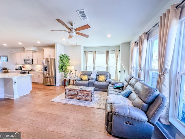 living room featuring visible vents, baseboards, light wood-type flooring, recessed lighting, and a ceiling fan