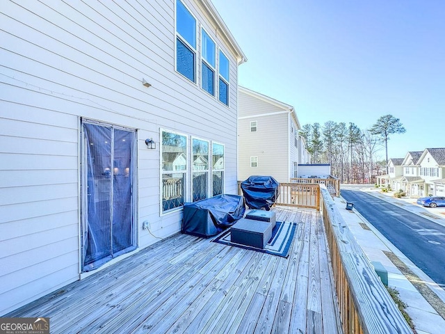 wooden terrace with a residential view and grilling area