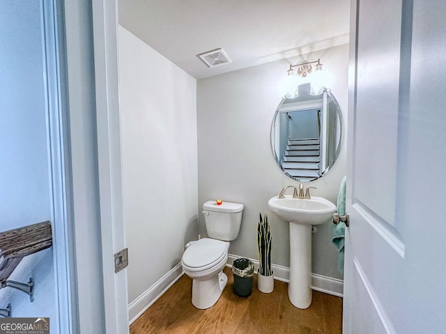 bathroom featuring visible vents, toilet, baseboards, and wood finished floors