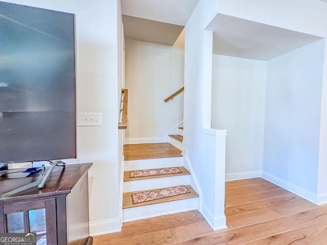 staircase with wood finished floors and baseboards