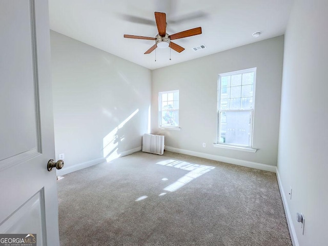 spare room with visible vents, baseboards, carpet flooring, and a ceiling fan