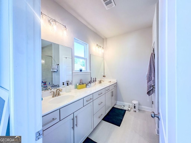 full bath featuring double vanity, visible vents, a stall shower, and a sink