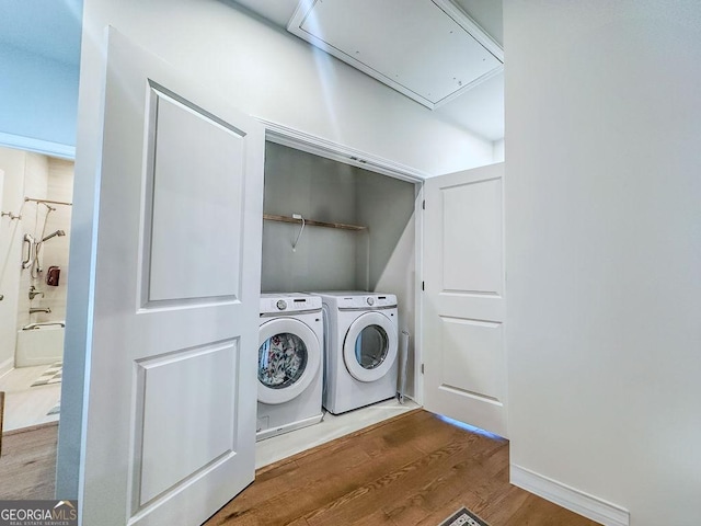 laundry room with wood finished floors, attic access, laundry area, and separate washer and dryer