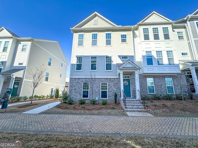 townhome / multi-family property featuring brick siding