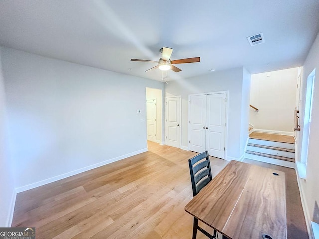 unfurnished office with visible vents, baseboards, light wood-style flooring, and a ceiling fan