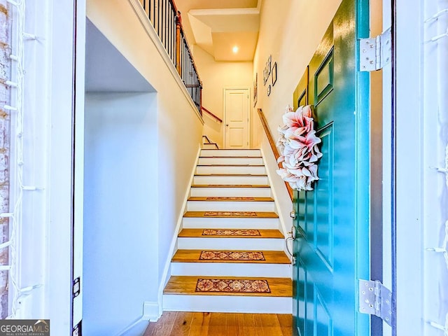 staircase featuring baseboards and wood finished floors