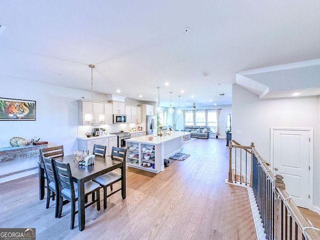 dining space with recessed lighting and light wood-type flooring