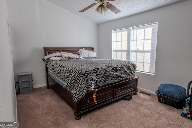 bedroom with visible vents, a textured ceiling, and carpet floors