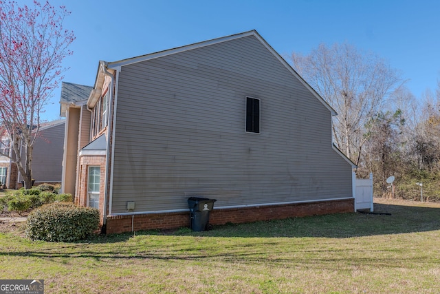 view of property exterior featuring a yard and brick siding