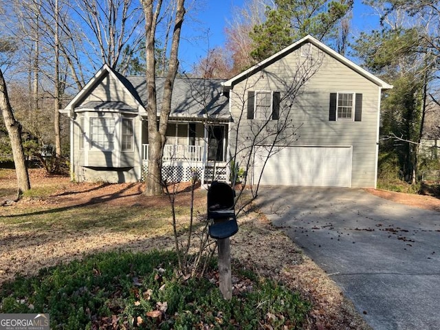 tri-level home with a garage, a porch, and driveway