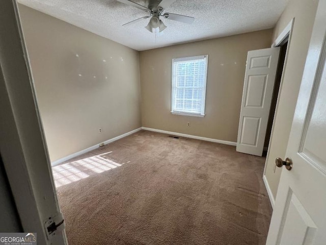 unfurnished room featuring baseboards, a textured ceiling, a ceiling fan, and carpet floors