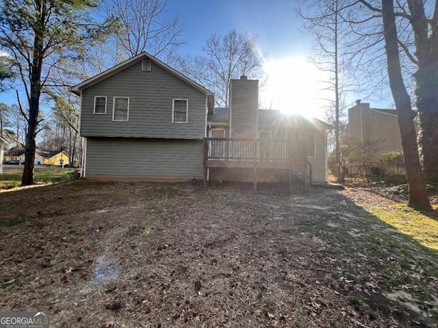 rear view of house with a chimney and a wooden deck