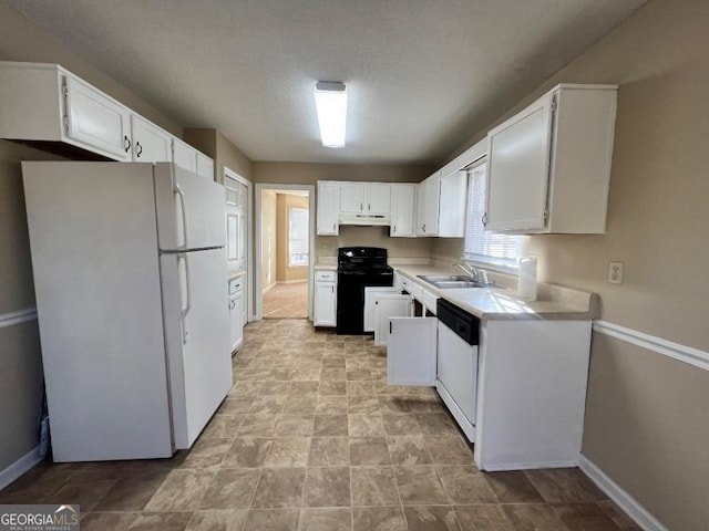 kitchen with a sink, white appliances, white cabinets, and light countertops