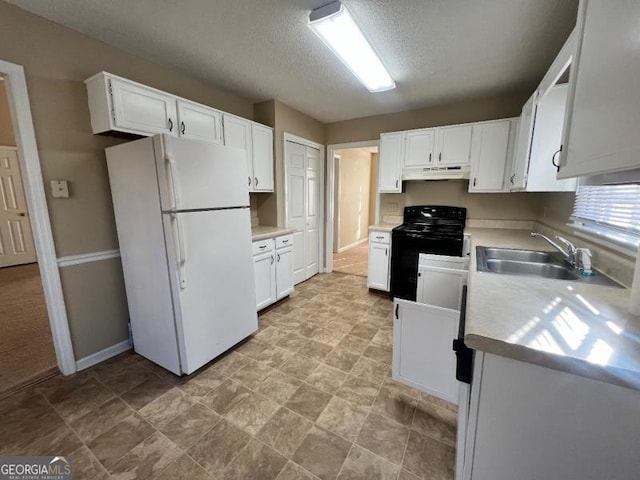 kitchen with black range, under cabinet range hood, a sink, white cabinetry, and freestanding refrigerator