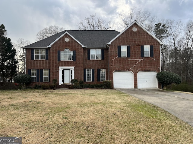 colonial home featuring brick siding, an attached garage, concrete driveway, and a front lawn