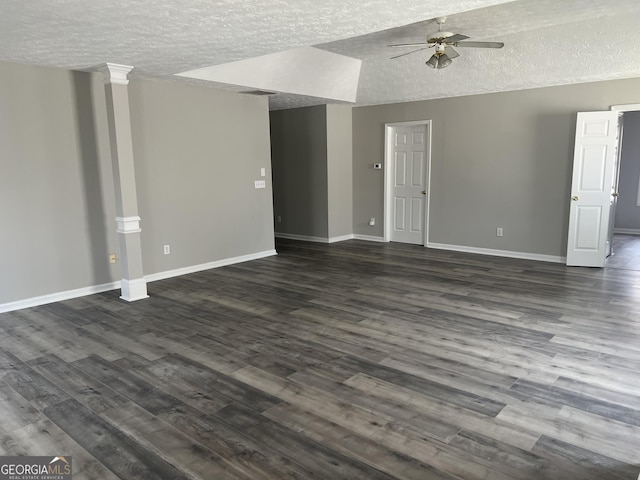 unfurnished living room with a ceiling fan, baseboards, dark wood-style flooring, vaulted ceiling, and a textured ceiling