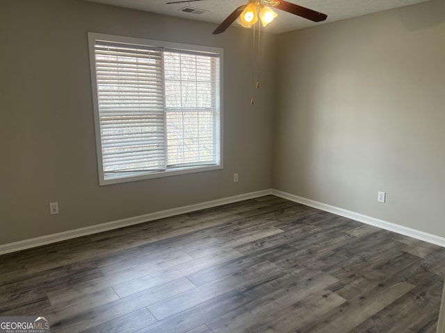 unfurnished room featuring visible vents, baseboards, dark wood-style flooring, and a ceiling fan