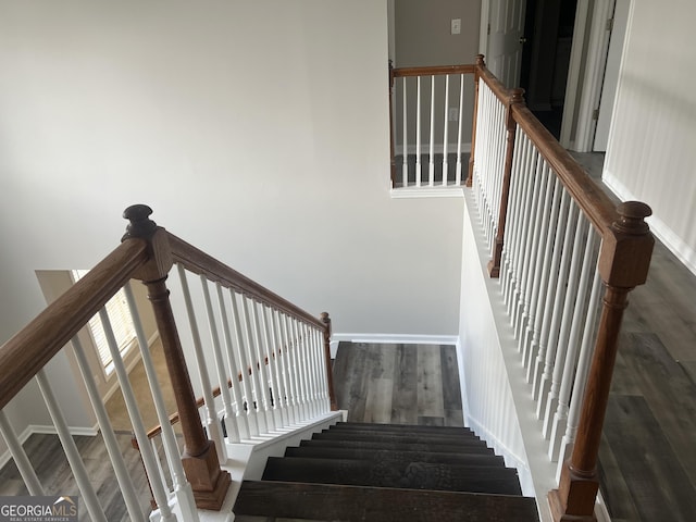 staircase with baseboards and wood finished floors