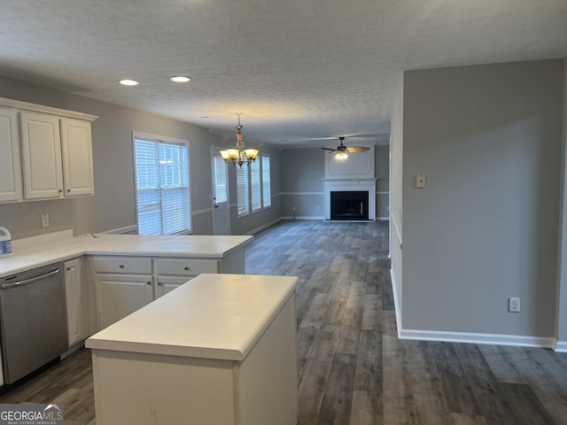 kitchen featuring stainless steel dishwasher, white cabinetry, a peninsula, a fireplace, and light countertops