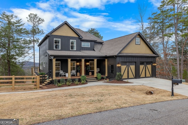 view of front of home with a porch, fence, roof with shingles, concrete driveway, and a front yard