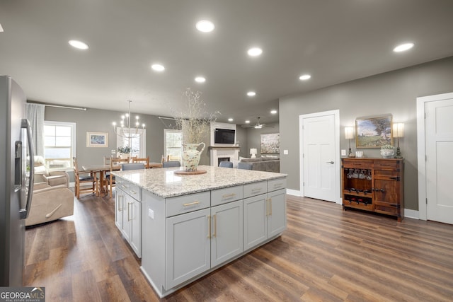 kitchen featuring a center island, stainless steel fridge with ice dispenser, open floor plan, recessed lighting, and dark wood-style flooring