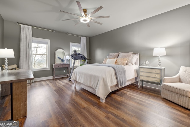 bedroom featuring dark wood finished floors, a ceiling fan, and baseboards