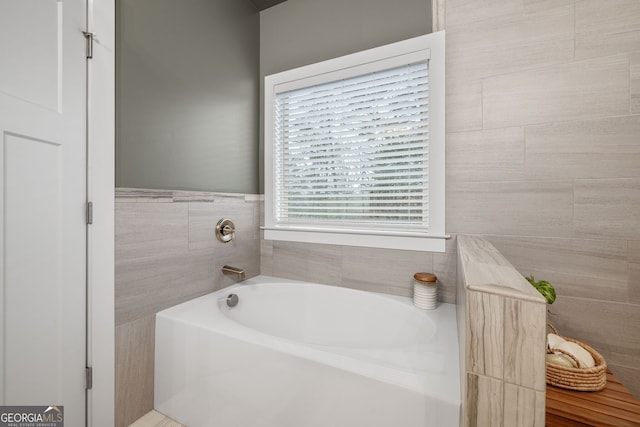 full bath featuring tile walls and a bath