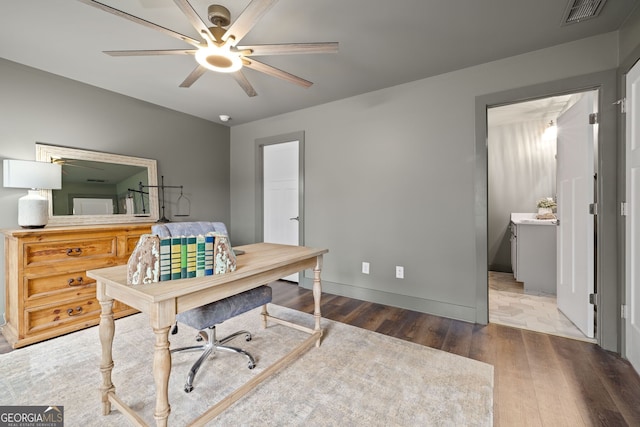 office space with visible vents, baseboards, ceiling fan, and wood finished floors