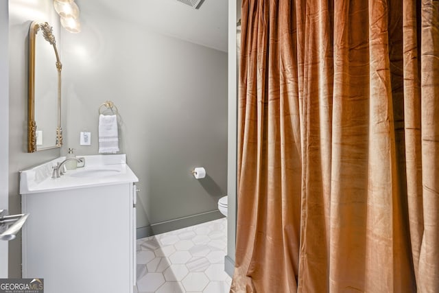 full bathroom featuring baseboards, toilet, vanity, and tile patterned flooring