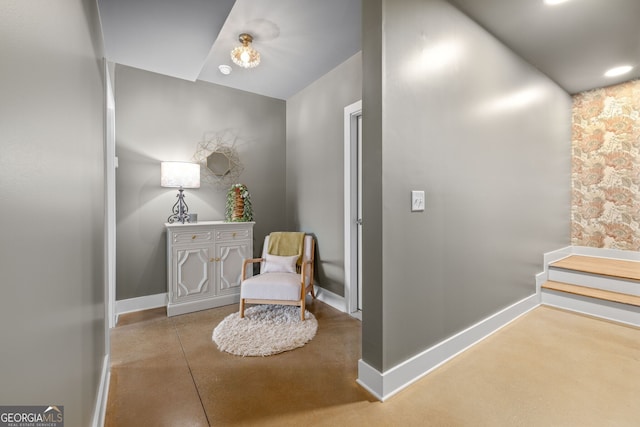 sitting room with baseboards and concrete floors