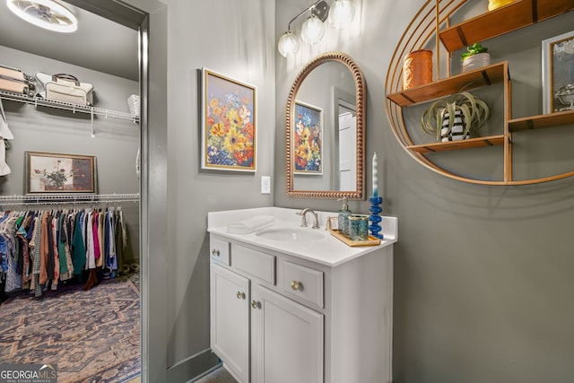 bathroom with vanity and a walk in closet