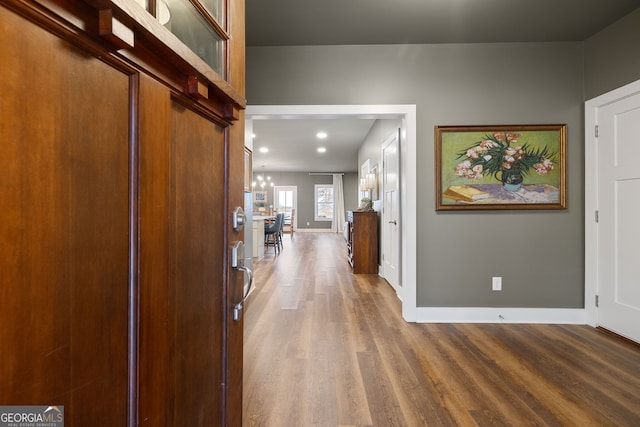 entryway with recessed lighting, baseboards, a notable chandelier, and wood finished floors