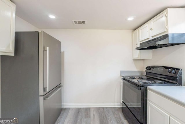 kitchen with electric range, visible vents, under cabinet range hood, white cabinetry, and freestanding refrigerator