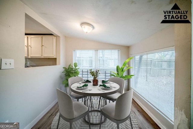 dining space with lofted ceiling, dark wood-style floors, and baseboards