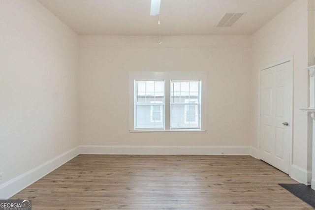 unfurnished room featuring visible vents, baseboards, wood finished floors, and a ceiling fan