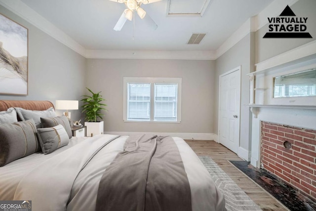 bedroom featuring visible vents, crown molding, ceiling fan, baseboards, and wood finished floors