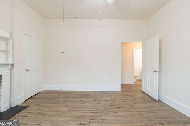 interior space with visible vents, ceiling fan, baseboards, and wood finished floors