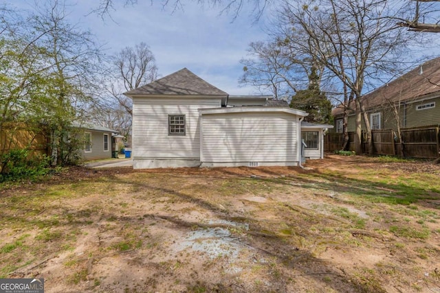 back of house featuring roof with shingles and fence