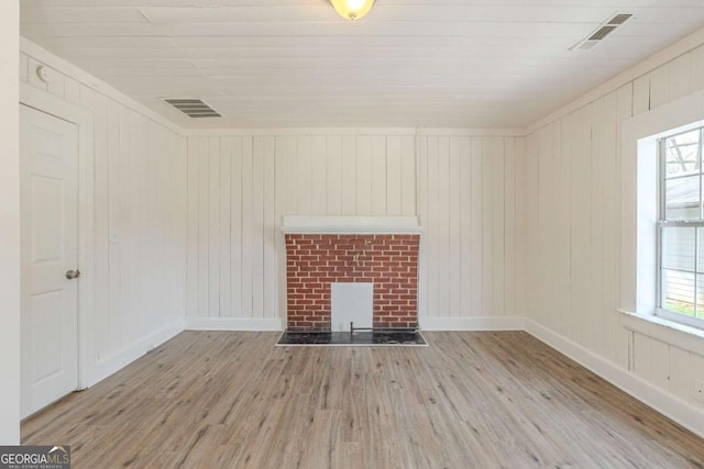 unfurnished living room with visible vents, baseboards, wood finished floors, and a fireplace