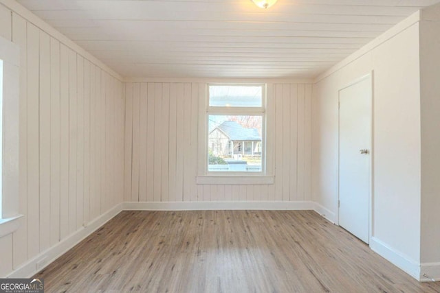 unfurnished room featuring baseboards and wood finished floors