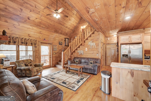 living room featuring wood ceiling, stairs, light wood-style flooring, wood walls, and lofted ceiling
