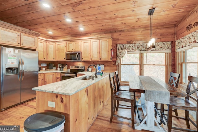 kitchen with a peninsula, a sink, light brown cabinetry, stainless steel appliances, and wooden ceiling