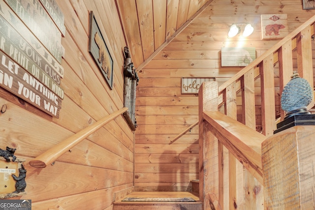 staircase featuring wooden walls