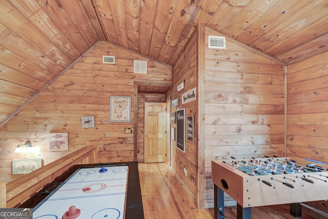 recreation room with wood walls, wooden ceiling, vaulted ceiling, and light wood-style floors