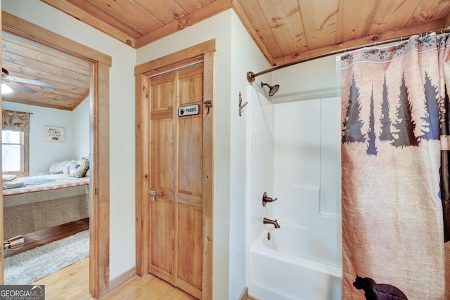 ensuite bathroom featuring wooden ceiling, wood finished floors, shower / tub combo with curtain, a ceiling fan, and baseboards