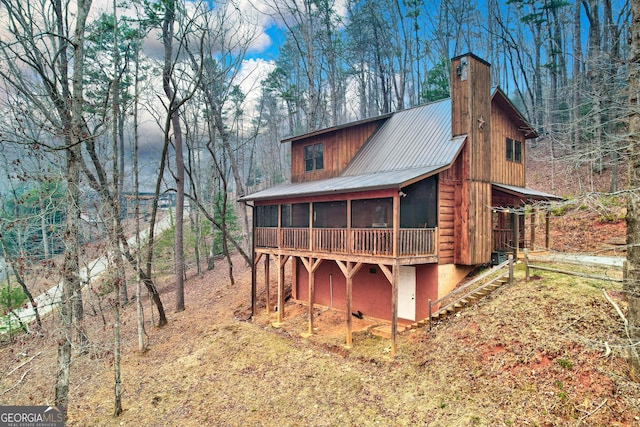 exterior space with a chimney and a sunroom