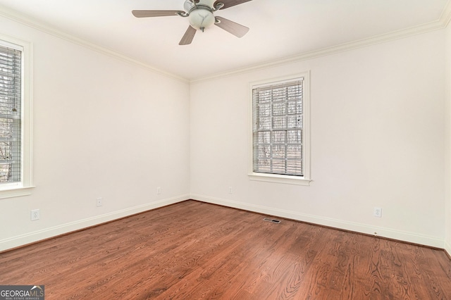 unfurnished room featuring visible vents, baseboards, ceiling fan, ornamental molding, and wood finished floors